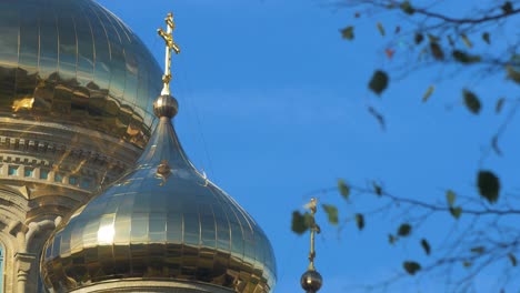 View-of-orthodox-St-Nicholas-Naval-Cathedral-golden-domes-and-crosses-on-blue-sky-in-sunny-autumn-day-at-Karosta,-Liepaja,-medium-shot