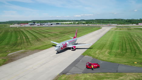 Low-fly-counter-clockwise-towards-a-jet2-aircraft-at-Leeds-Bradford-airport-with-a-Jet2-airplane-on-the-runway