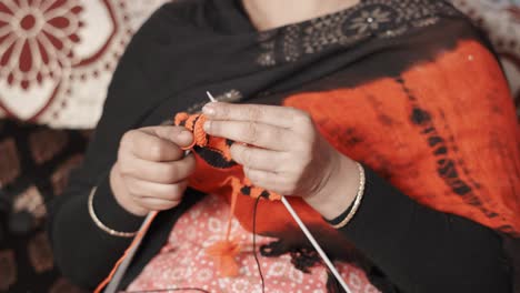 Old-woman-knitting-with-black-and-red-wool-and-two-needle-crafts