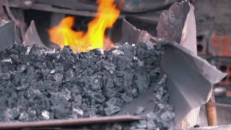Close-Shot-of-Blacksmith-Stoking-the-Fires-of-the-Forge