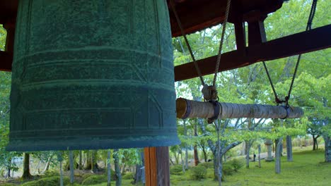 Große-Japanische-Glocke,-Umgeben-Von-Bäumen-In-Einem-Wunderschönen-Garten-In-Kyoto,-Japan,-Nahaufnahme,-Sanfte-Beleuchtung,-Zeitlupe-4k