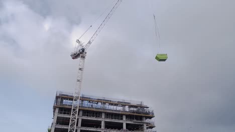 Construction-crane-lifts-a-6m-waste-bin-to-top-level-of-construction-site