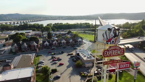 Aerial-turn-features-Turkey-Hill-ice-cream-manufacturer-and-tourist-destination-with-Susquehanna-River-and-Route-30-traffic-in-Columbia,-Pennsylvania