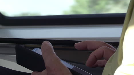 Close-up-of-a-man's-hand-using-a-smartphone-on-a-moving-train