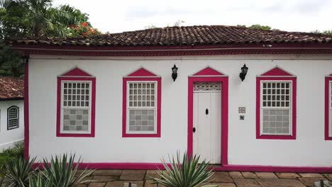 Left-to-right-panning-shot-of-a-pink-and-white-building-in-Pirenopolis,-Brazil
