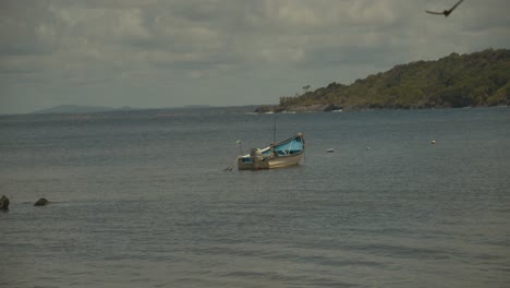 Ein-Fischerboot,-Das-Im-Meer-Verankert-Ist,-Mit-Bergen-Im-Hintergrund