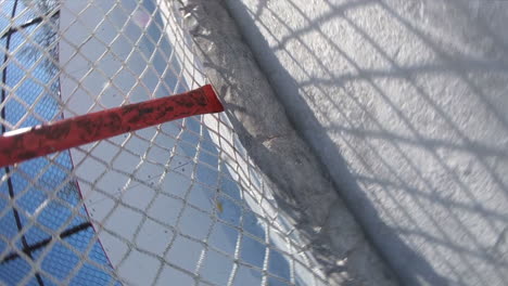Einzigartiger-Blick-Auf-Einen-Puck,-Der-Während-Eines-Freiluftspiels-Auf-Einem-Eisfeld-In-Ein-Hockeynetz-Schießt