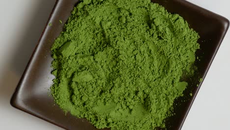 Match-green-tea-powder-on-a-brown-stone-plate-rotating-in-center-of-frame