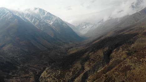 Aerial-drone-shot-closing-on-snowy-mountains-on-a-cloudy-day-in-Cordillera-de-los-Andes-4K