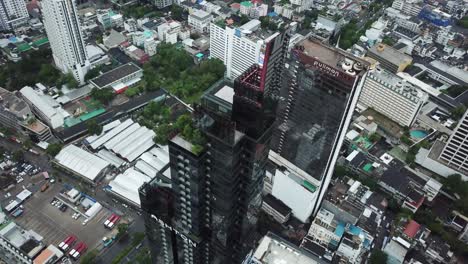 Ashton-Silom-and-Pullman-Bangkok-Hotel,-Thailand,-Birds-Eye-Aerial-of-Modern-Skyscrapers-in-Asian-Metropolis