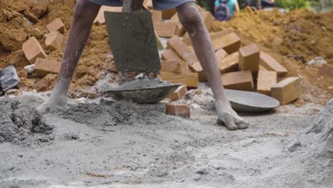Indian-labourer-or-worker-loading-the-cement-onto-the-head-pan-with-a-hoe