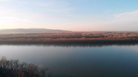 Eine-Luftdrohnenaufnahme-Der-Donau-In-Osteuropa-Mit-Blick-Auf-Den-Horizont-Am-Abend,-Wenn-Die-Sonne-Untergeht