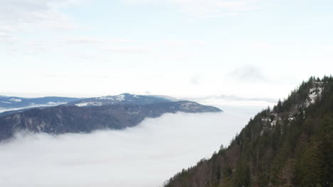 Aerial-jib-down-of-low-hanging-clouds-in-beautiful-mountain-valley