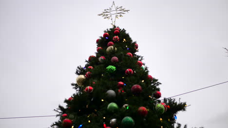 A-huge-tall-Christmas-tree-background-with-a-star-on-top-and-many-festive-holiday-ornaments,-lights-and-decorations