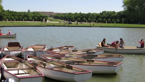 Menschen,-Die-Auf-Kleinen-Booten-In-Einem-See-Der-Schlossgärten-Von-Versailles,-Paris,-Frankreich,-Paddeln