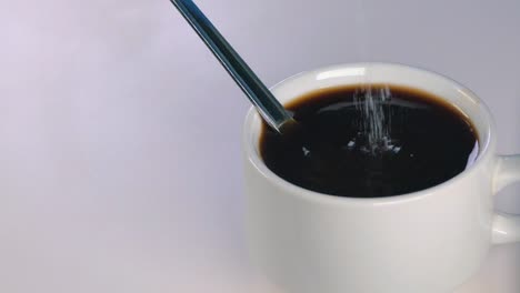 Zeitlupenaufnahme-Von-Weißem-Zucker,-Der-In-Einen-Schwarzen-Kaffee-Gegossen-Wird