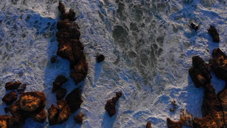Spectacular-top-down-aerial-drone-view-of-rough-waves-crashing-the-rock-shore