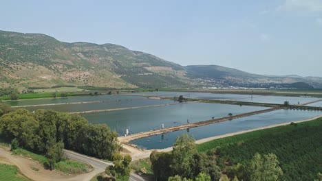 Aerial-footage-of-agricultural-water-reservoir-in-a-large-area-of-fields