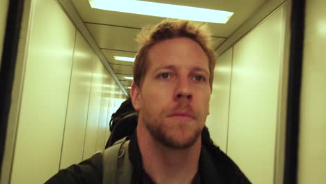 man-selfie-walking-through-tight-airport-corridor