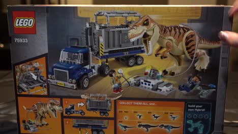 Lego-Spielzeugkiste-Video-Mit-Hand,-Die-Auf-Jurassic-World-Dinosaurier-Zeigt,-Die-Im-Bauset-Enthalten-Sind