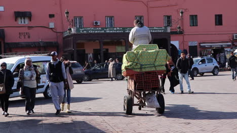 Geschäftige-Stadtstraße-In-Marrakesch-Marokko-Mit-Menschen-Und-Eseln,-Die-Einen-Behelfsmäßigen-Karren-Ziehen