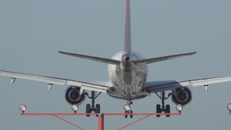 An-airliner-about-to-land-at-Los-Angeles-International-Airport-behind-approach-lights,-in-slow-motion