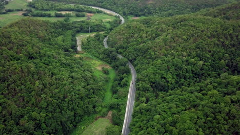 Logistic-concept-aerial-view-of-countryside-road-passing-through-the-lush-greenery-and-foliage-tropical-rain-forest-mountain-landscape