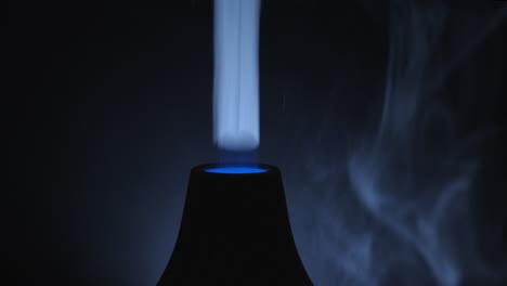 A-Dark-Room-With-A-Turned-On-Ultrasonic-Diffuser-Releasing-White-Smoky-Aromatic-Air-From-Essential-Oil---Close-Up-Shot