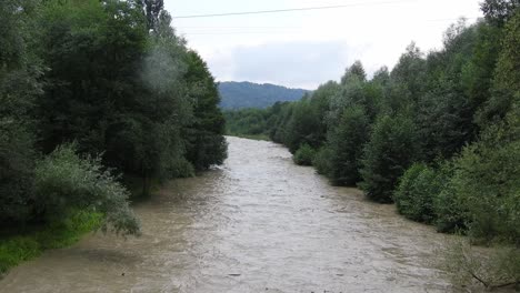 Aufgewühlter-Fluss,-Der-Sich-Nach-Einem-Starken-Sturm-Seinen-Weg-Durch-Die-Bäume-Bahnt