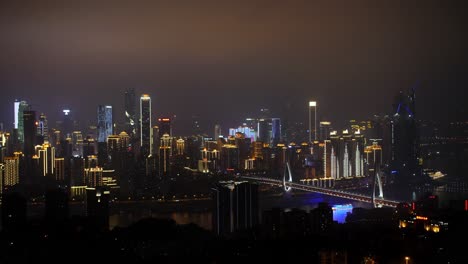 Skyline-of-the-city-showing-the-financial-district-and-the-Yang-Gong-Bridge-at-night,-Locked-establishing-shot