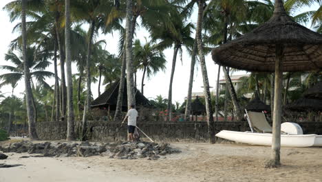 Mauritian-local-fisherman-walking-along-beach-with-rod-and-line,pan-shot