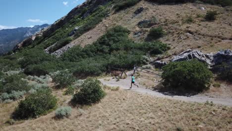 Drone-Shot-following-an-active-man-running-on-the-outdoor-Wasatch-Mountain-trails-above-Draper-City,-Utah