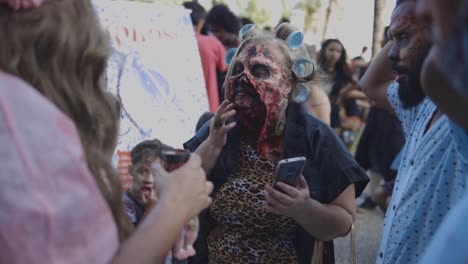 Close-up-of-a-make-up-artist-in-style-applying-prosthetics-before-Halloween-walk-of-zombies-on-the-Day-of-the-Dead-in-Copacabana-among-the-crowd