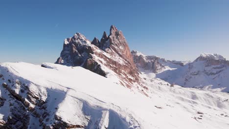 Dolomites-mountain-peak-covered-in-snow-on-a-sunny-day,-aerial-paning