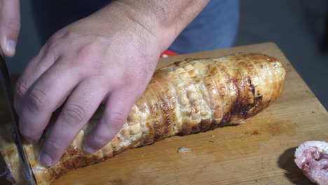 Man-slicing-Wrapped-Chicken-stuffed-in-mouthwatering,-delicious-rolled-chicken