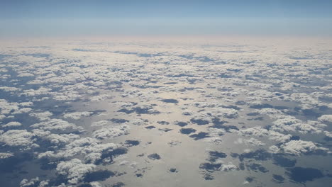 Aerial-top-down-of-group-of-small-clouds-reflecting-on-ocean
