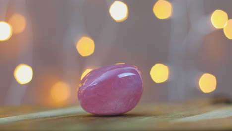 Love-healing-rose-quartz-gemstone-on-wooden-table-with-lights