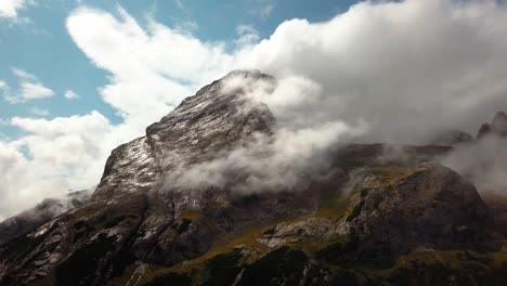 Alto-Pico-De-Dolomita-En-El-Norte-De-Italia-Con-Una-Cima-Rocosa-Y-Nublada-Durante-Un-Día-Claro-De-Invierno,-Un-Dron-Aéreo-Sale