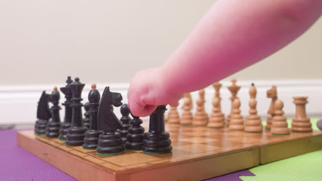 Baby's-hands-moving-chess-pieces