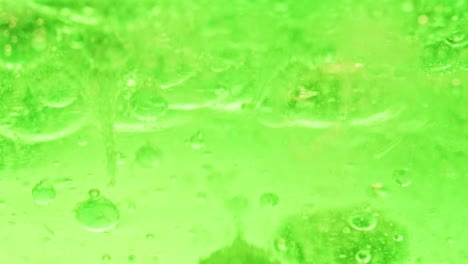 Makroaufnahme-Von-Großen-Grünen-Blasen,-Die-In-Hellgrünes-Wasser-Tropfen