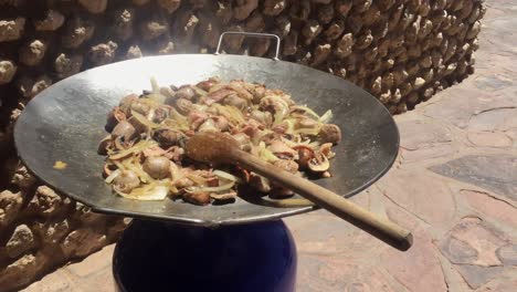 Sizzling-chicken-stir-fry-in-an-enormous-wok,-with-large-wooden-spoon