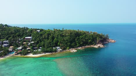 Paradise-remote-tropical-island-with-hotels-and-villas-in-front-of-calm-clear-sea-water-of-turquoise-bay-in-Koh-Phangan,-Thailand