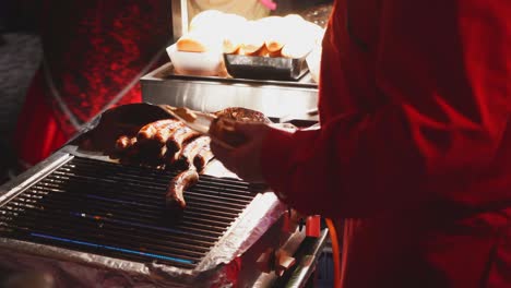 Close-up-shot-of-man-Grilling-roast-sausages-outside-on-the-grill-during-the-party-event