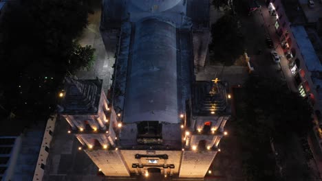 Nighttime-aerial-camera-looking-straight-down-and-then-pulling-back-and-pitching-up-showing-the-Catedral-de-San-Gervasio-in-Valladolid,-Yucatan,-Mexico