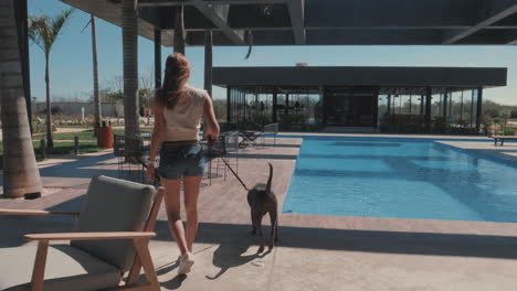 Junge-Frau,-Die-Ihren-Hund-Im-Freien-Am-Poolbereich-Spazieren-Führt,-Zeitlupe