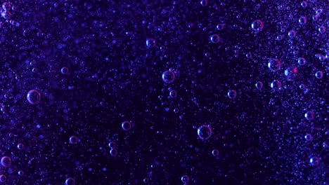 Burbujas-De-Color-Púrpura-Oscuro-Se-Elevan-Misteriosamente-Sobre-Un-Fondo-Negro-Mientras-Estas-Pequeñas-Esferas-Se-Elevan-Una-Cascada-De-Burbujas-Más-Pequeñas-Caen-En-El-Fondo-Mostrando-Las-Corrientes-Creadas-Por-Las-Burbujas-Más-Grandes