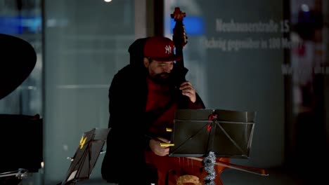 Street-musician-performing-in-downtown-munich-during-night