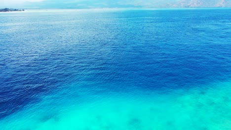 Aerial-of-the-beautiful-blue-waters-waters-and-a-scenic-view-of-mountains-on-the-horizon