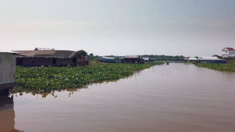 Travelling-Down-the-River-Near-Tonle-Sap-in-Cambodia-Past-Floating-Houses-and-Boats