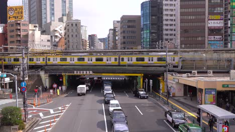 Train-passing-over-the-elevated-tracks-in-Tokyo,-Japan---medium-shot